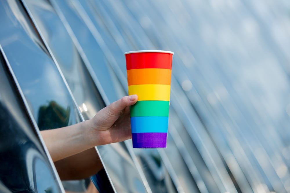 Hand Holding a Rainbow Colored Cup 